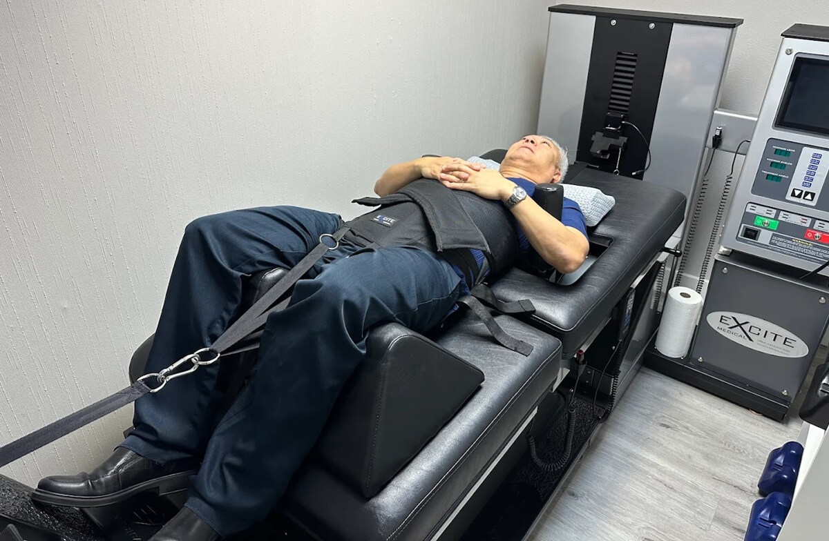 Dr. Hoa Nguyen with the DRX9000 spinal decompression machine at Dallas Spine Center in Carrollton, TX