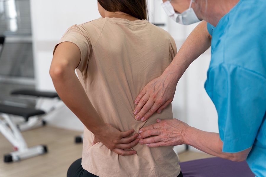 Chiropractor examining a patient with degenerative disc disease back pain