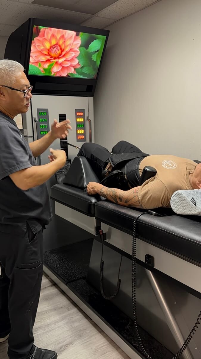 Dr. Hoa Nguyen explaining spinal decompression treatment to a patient in Carrollton, TX