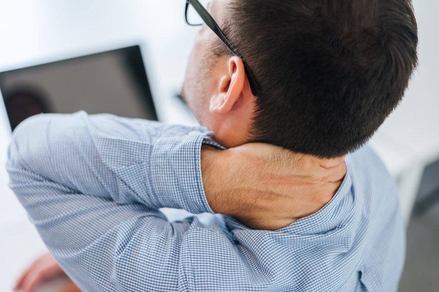 Man holding the back of his neck in pain
